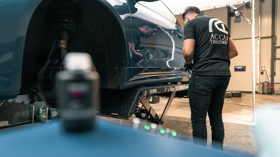A mechanic examines a car lift in a garage, focusing on vehicle repairs and maintenance.